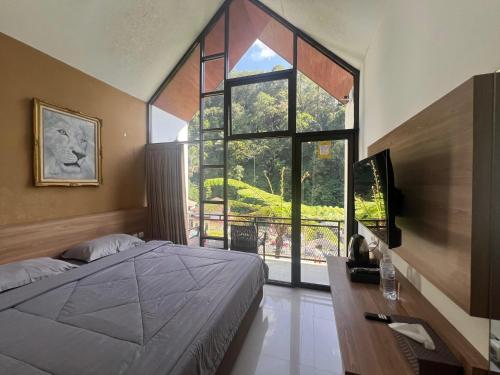 MargawinduにあるKampung Karuhan Eco Green Park Sumedangのベッドと大きな窓のある寝室
