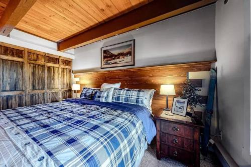 Un dormitorio con una cama y un techo de madera. en Cozy Condo Scenic Balcony Adjacent Golf Course, en Big Sky