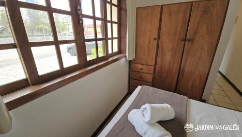 a room with a bed with two rolls of towels at Jardim das Gales Bombinhas in Bombinhas