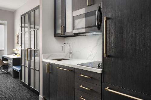 a kitchen with wooden cabinets and a sink at Residence Inn by Marriott Chicago Downtown Magnificent Mile in Chicago