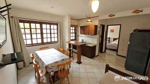 a kitchen and dining room with a table and chairs at Jardim das Gales Bombinhas in Bombinhas