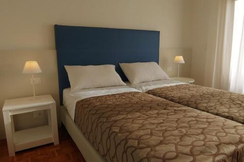 a bedroom with a large bed with a blue headboard at casa a schiera, a 150mt dal mare in Lido di Jesolo