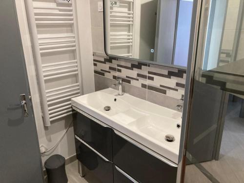 une salle de bain avec un lavabo et un miroir dans l'établissement Maison proche plage avec jardin, prêt vélos, internet et espace lingerie - FR-1-426-545, à Saint-Hilaire-de-Riez