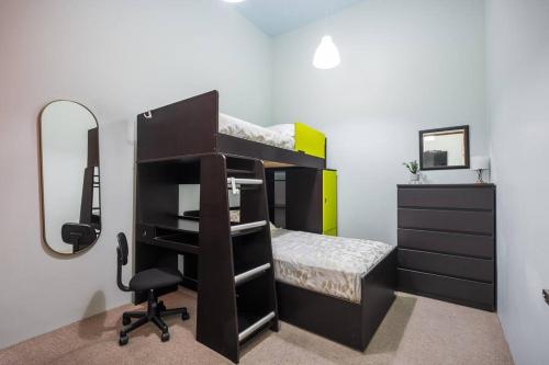 a bedroom with a bunk bed with a mirror and a chair at Acogedor departamento en Roma in Mexico City