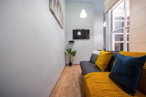 a living room with a couch and a window at Acogedor departamento en Roma in Mexico City