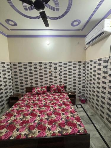a bedroom with a bed with pink flowers on it at Shri R M Home Stay in Faizābād