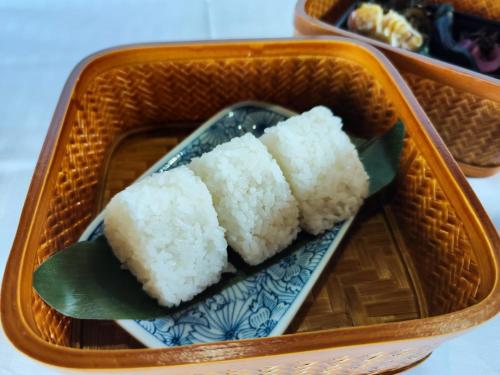 a tray of rice on a blue and white plate at NIPPONIA Sado 佐渡相川 金山町 in Sado