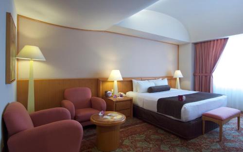a hotel room with a bed and two chairs at Crowne Plaza Hotel Mexico City North-Tlalnepantla by IHG in Mexico City