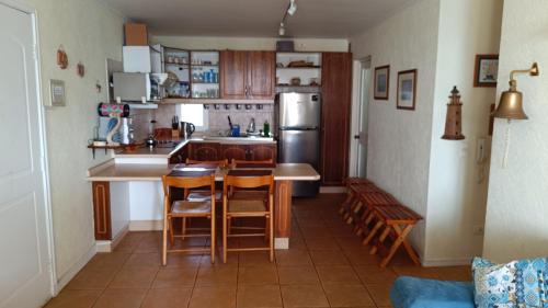 a kitchen with a table and chairs and a refrigerator at Departamento Bahía Pelícanos, Horcón in Puchuncaví