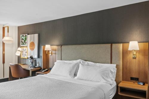 a bedroom with a large bed with white pillows at Holiday Inn Niagara Falls State Park Entry by IHG in Niagara Falls