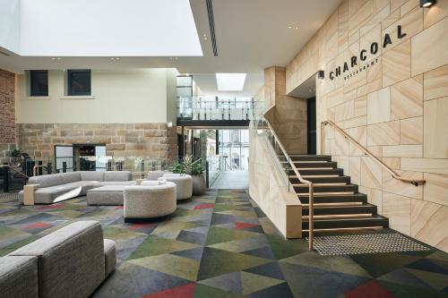 a lobby with stairs and couches in a building at RACV Hobart Hotel in Hobart