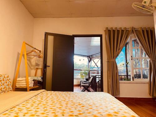 a bedroom with a bed and a door to a balcony at BắpHouseHomestay in Da Lat