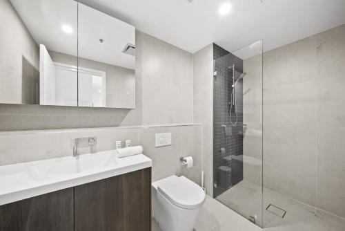 a bathroom with a toilet and a sink and a shower at Refined 2-Bed With Luxurious Building Amenities in Belconnen
