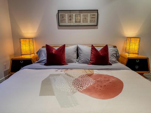 a bedroom with a bed with red pillows and two lamps at Le Willow Exitchalets Lake, Billard & Spa in Val-David