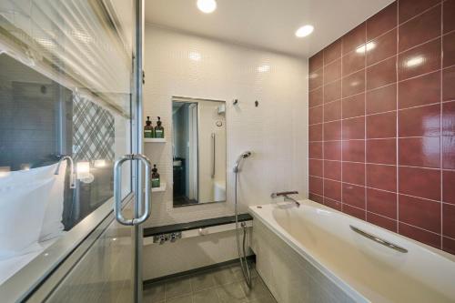 a bathroom with a tub and a sink and a mirror at ANA Crowne Plaza Kanazawa by IHG in Kanazawa