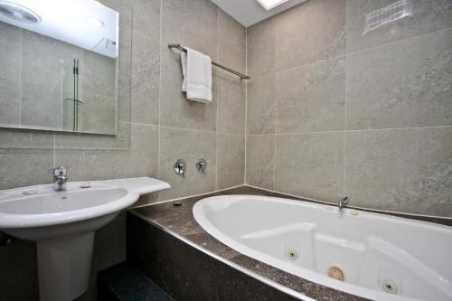 a bathroom with a bath tub and a sink at Jesmond Executive Villas in Newcastle
