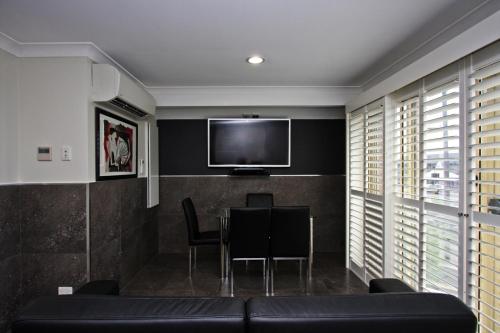 a living room with a table and a flat screen tv at Jesmond Executive Villas in Newcastle