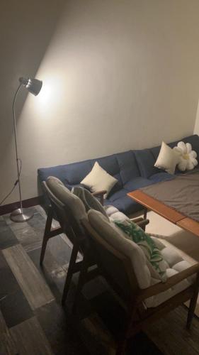 a living room with a couch and a chair at 阿霞袂睏MAMAzzzzHostel in Tainan