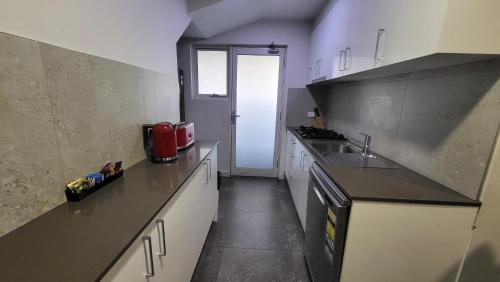 a kitchen with white cabinets and a black counter top at Jesmond Executive Villas in Newcastle