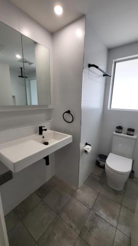 a white bathroom with a sink and a toilet at Jesmond Executive Villas in Newcastle