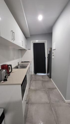 a kitchen with white counters and a black refrigerator at Jesmond Executive Villas in Newcastle