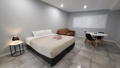 a bedroom with a bed and a table and a chair at Jesmond Executive Villas in Newcastle