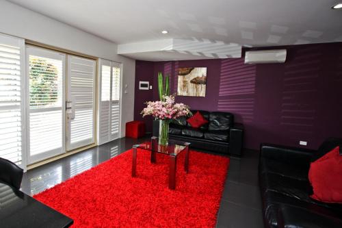 a living room with a couch and a red rug at Jesmond Executive Villas in Newcastle
