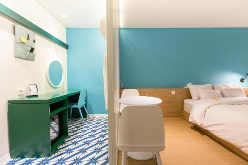 a bedroom with a green desk and a bed at Hotel Yeogiuhtte Gangneung Gyeongpo in Gangneung