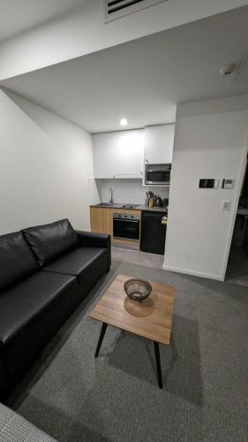 a living room with a black couch and a coffee table at Jesmond Executive Villas in Newcastle