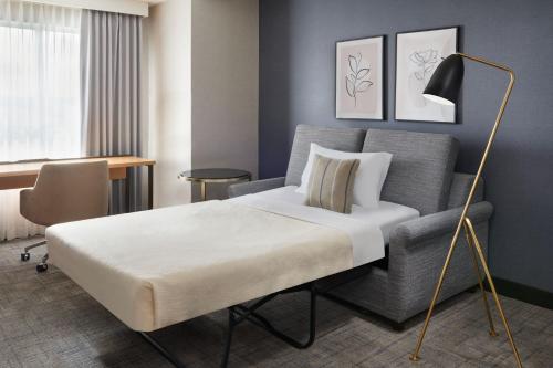 a bed and a chair in a room at Residence Inn by Marriott Calgary Airport in Calgary