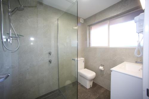 a bathroom with a shower and a toilet and a sink at Jesmond Executive Villas in Newcastle