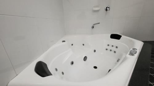 a white bath tub with a faucet in a bathroom at Jesmond Executive Villas in Newcastle