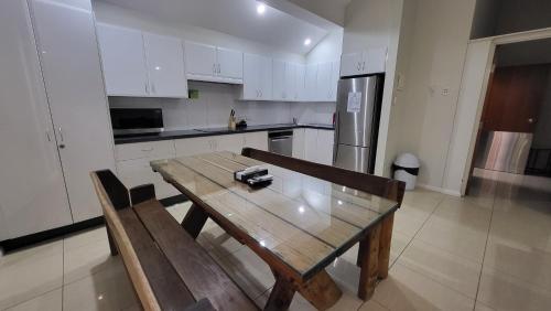 a kitchen with a wooden table and a refrigerator at Jesmond Executive Villas in Newcastle