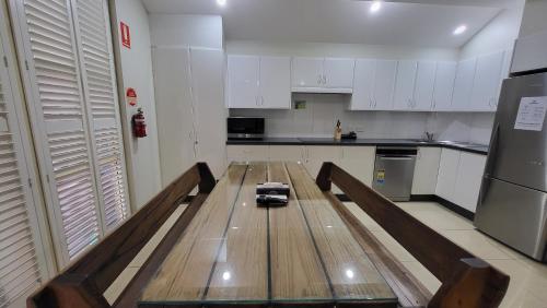 a kitchen with a wooden table in the middle at Jesmond Executive Villas in Newcastle