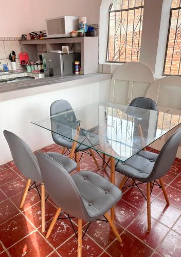 a glass dining room table with four chairs and a counter at Casa para siete personas en Lo De Marcos, Nayarit in Lo de Marcos