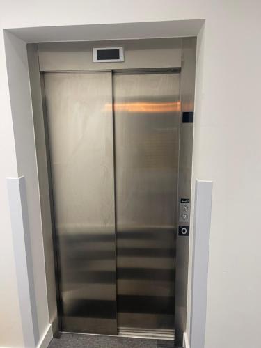 a elevator in a building with a metal door at A comfortable Apartment in Brierfield