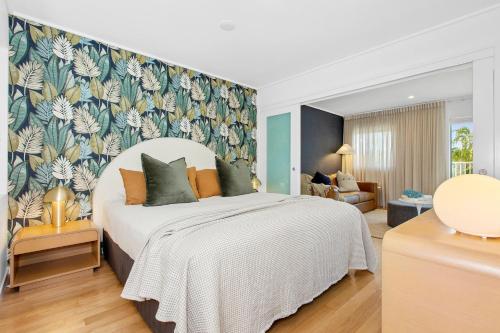 a bedroom with a large white bed in a room at The Sand Resort Kingscliff - Holiday Management Co. in Kingscliff