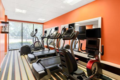 a gym with cardio equipment in a room with orange walls at Holiday Inn Express Atlanta Galleria-Ballpark Area by IHG in Atlanta