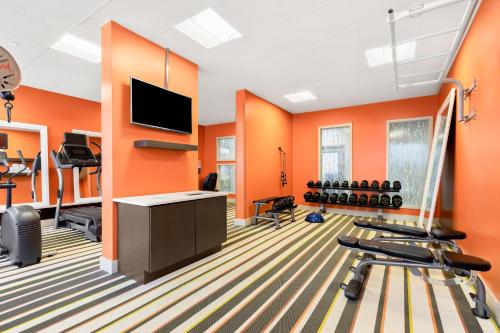 an office with orange walls and a gym with exercise equipment at Holiday Inn Express Atlanta Galleria-Ballpark Area by IHG in Atlanta
