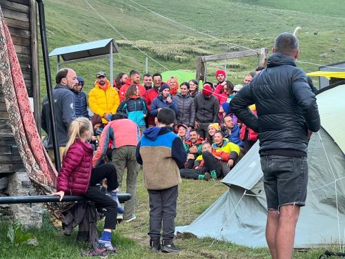 a crowd of people standing outside of a tent at Zeta Camping in Jut'a