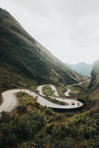 a winding road on a hillside with cars on it at Cheers Hostel Hanoi in Hanoi