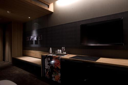 a room with a tv on the wall and a table at Hotel Dùa in Kaohsiung