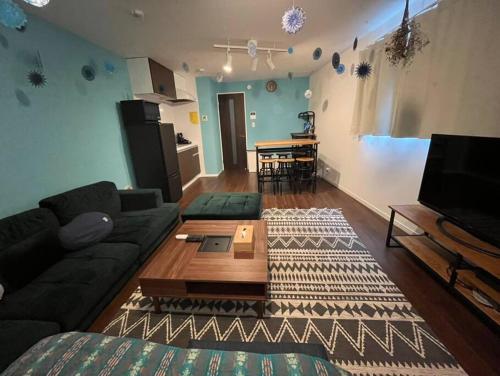 a living room with a couch and a table at Rakuna Inn 動 Sasazuka in Tokyo