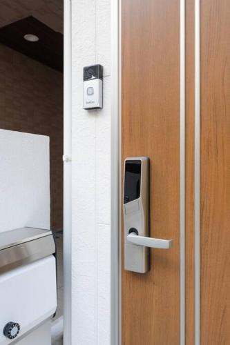 a wooden door with a soap dispenser on it at Rakuna Inn 動 Sasazuka in Tokyo