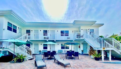 a building with a patio with chairs and umbrellas at Southwinds Inn by The Gold Nests in Hollywood