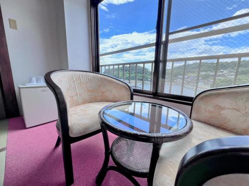 a living room with a glass table and chairs at Ichifukuso in Tara