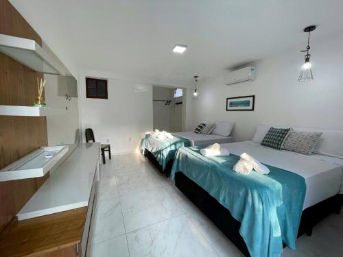a bedroom with two beds and a sink in it at Do Adriano Suites in Búzios