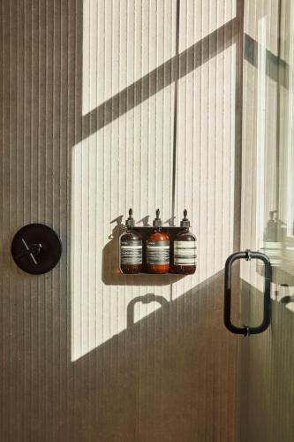 a bathroom with three jars on a wall at Archway Hotel Residence in Philadelphia