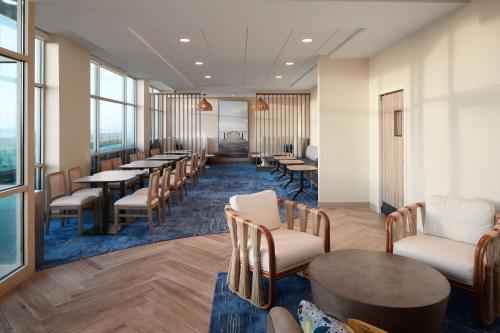 a waiting room with tables and chairs and windows at SpringHill Suites by Marriott Virginia Beach Oceanfront in Virginia Beach
