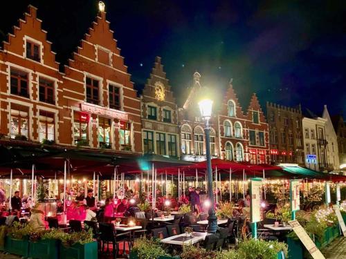 un groupe de personnes assises aux tables devant les bâtiments dans l'établissement Studio cocooning près de Lille avec jardin, parking sécurisé et accès facile aux transports. - FR-1-510-215, à Saint-André